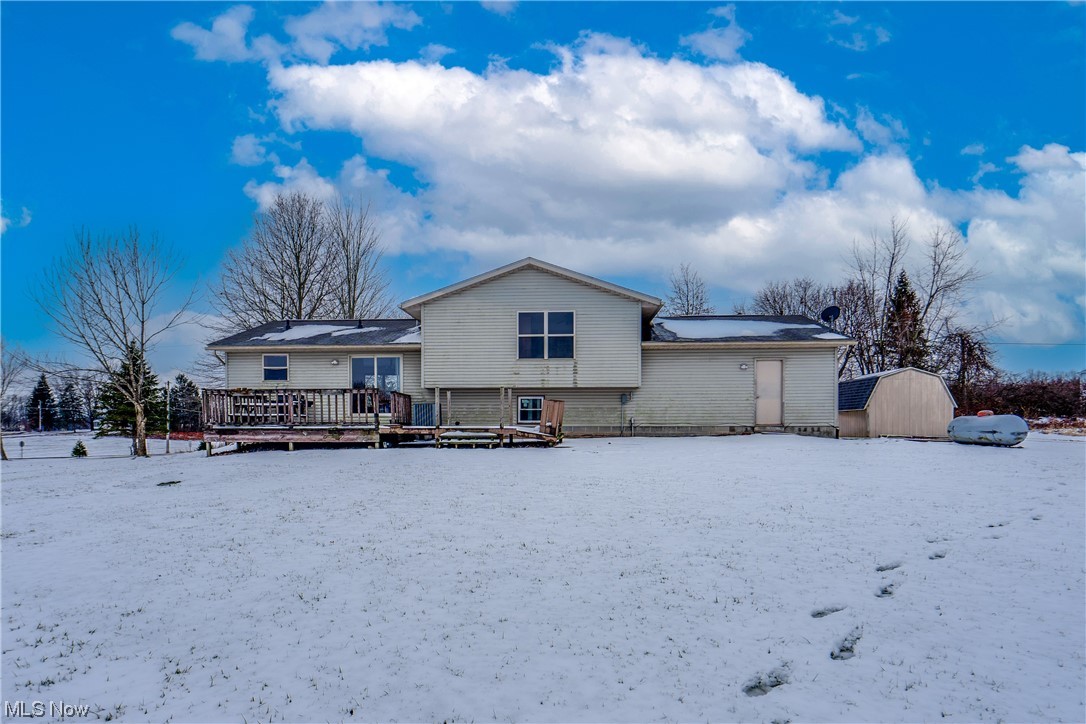 5303 Laubert Road Atwater, OH 44201 - Photo 5 of 37 Snow covered property featuring a storage unit and a wooden deck