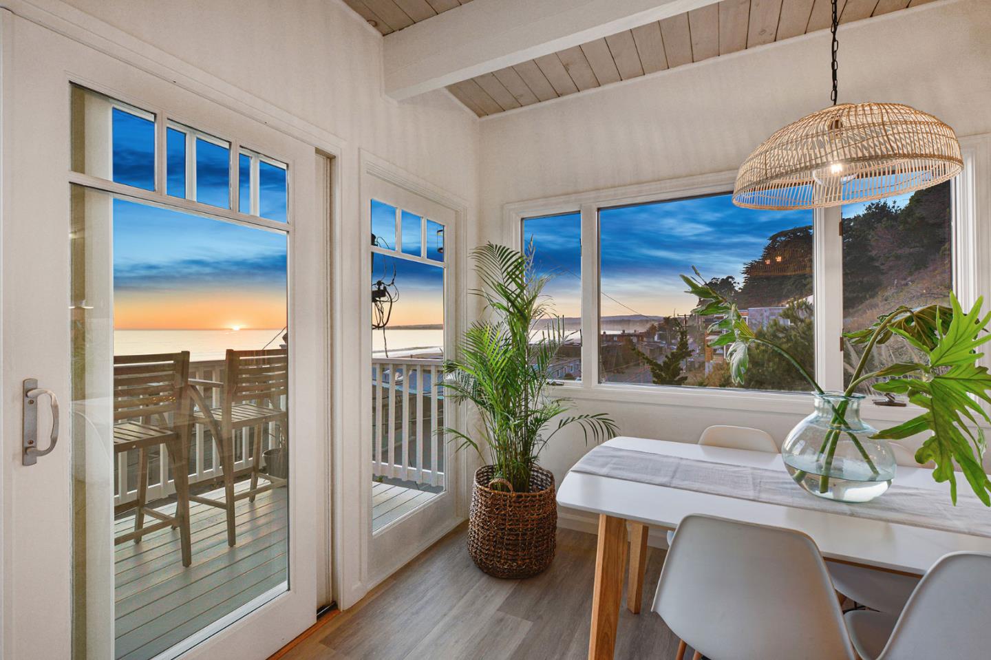 a dining room with furniture potted plants and wooden floor