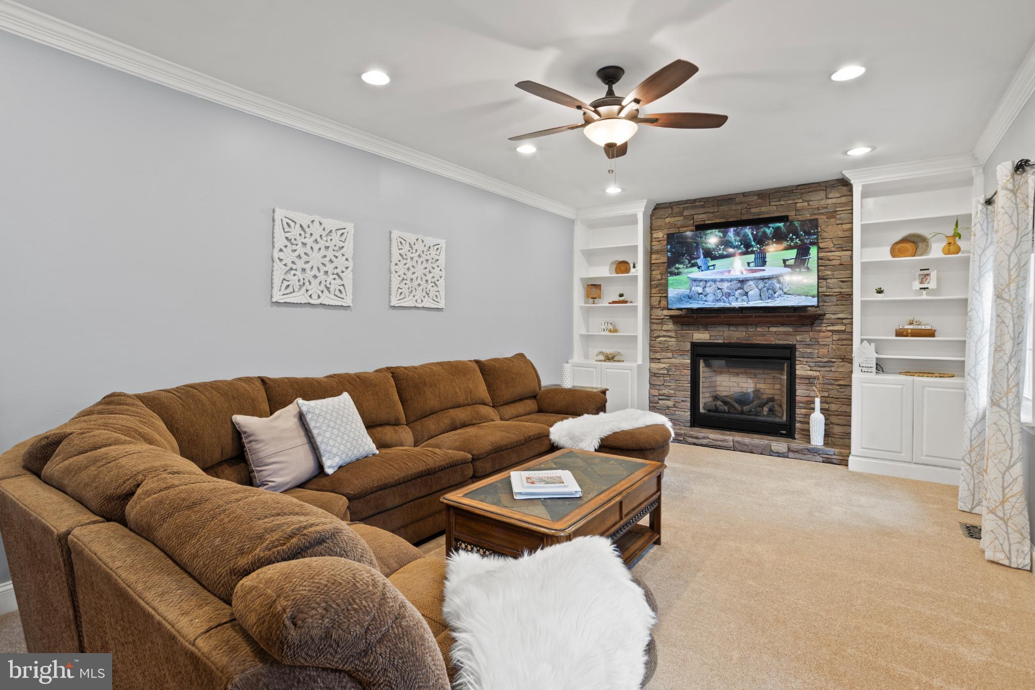 1860 Battery Lane Owings, MD 20736 - Photo 31 of 120 a living room with furniture a fireplace and a flat screen tv