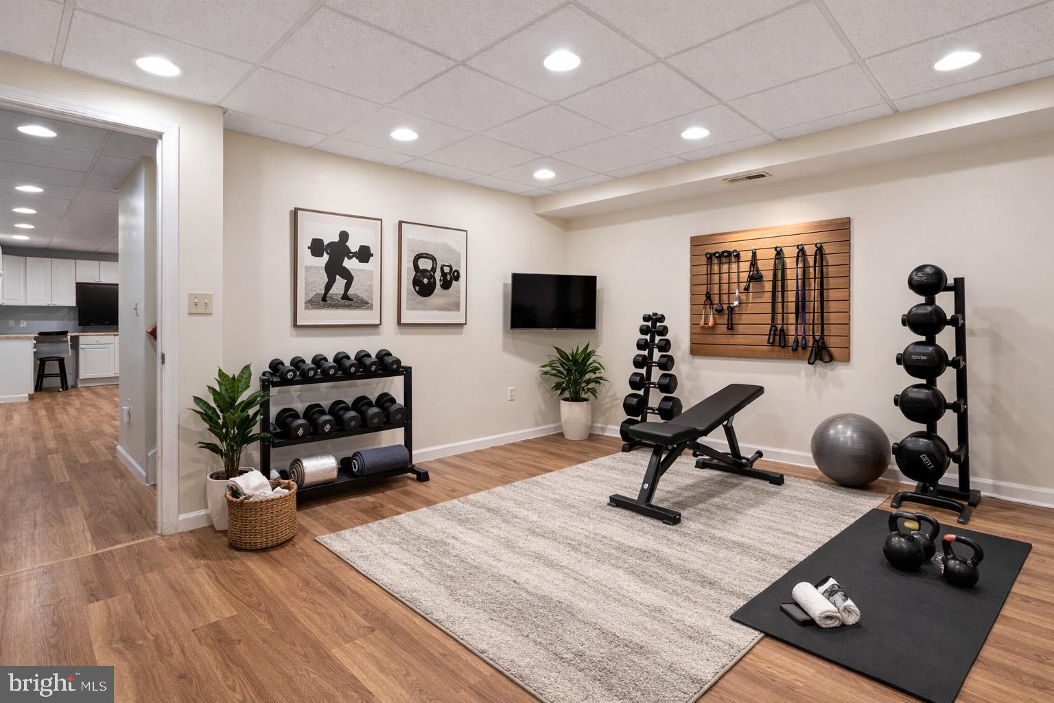 1860 Battery Lane Owings, MD 20736 - Photo 85 of 120 a living room with furniture a flat screen tv and gym equipment