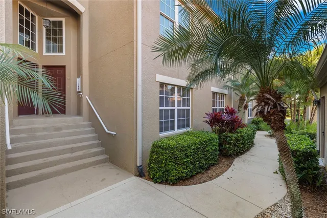 a view of a house with a yard and potted plants