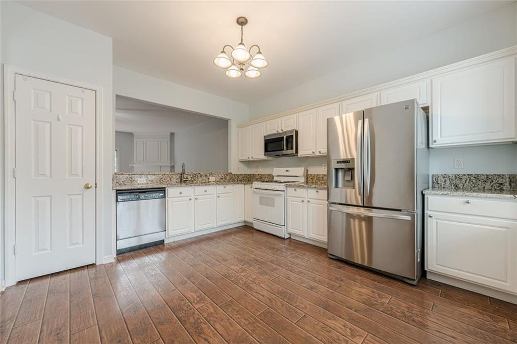 5589 Trace Views Drive Norcross, GA 30071 - Photo 18 of 58 a kitchen with white cabinets and white appliances