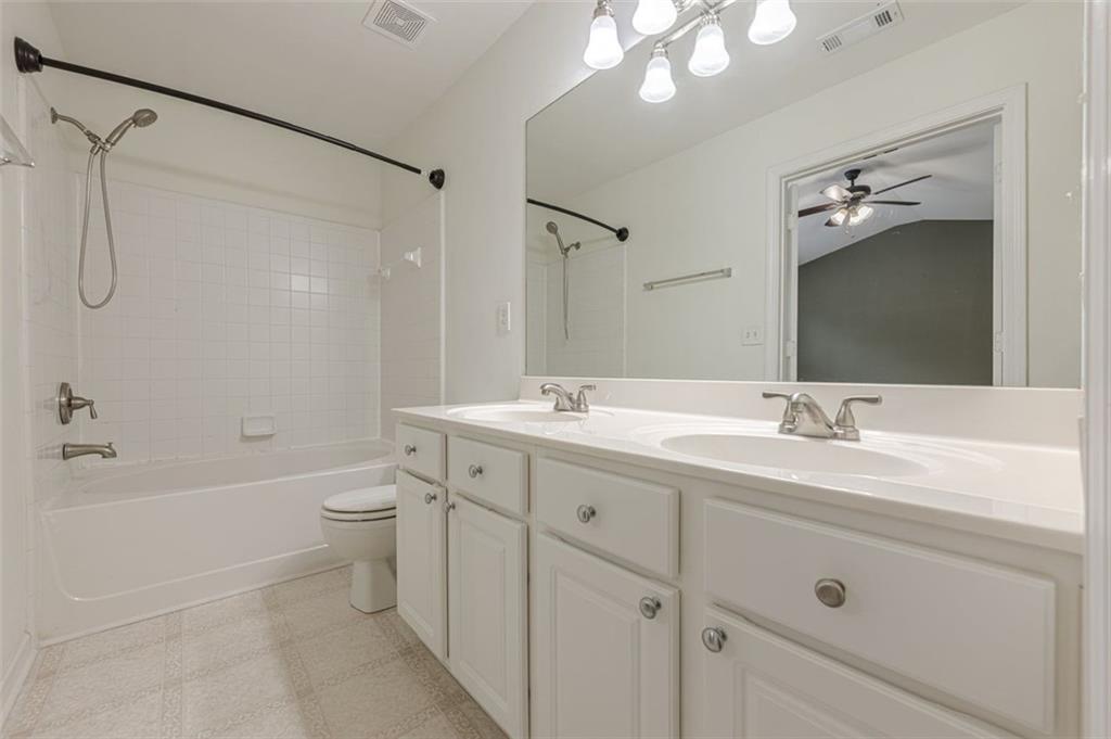 5589 Trace Views Drive Norcross, GA 30071 - Photo 29 of 58 a bathroom with a double vanity sink a toilet a mirror and shower