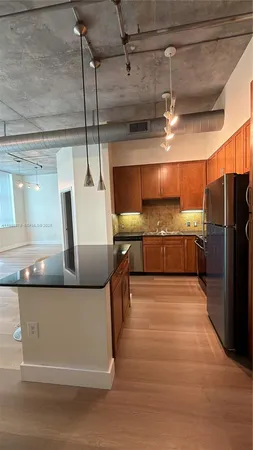a kitchen with stainless steel appliances granite countertop a sink and a refrigerator