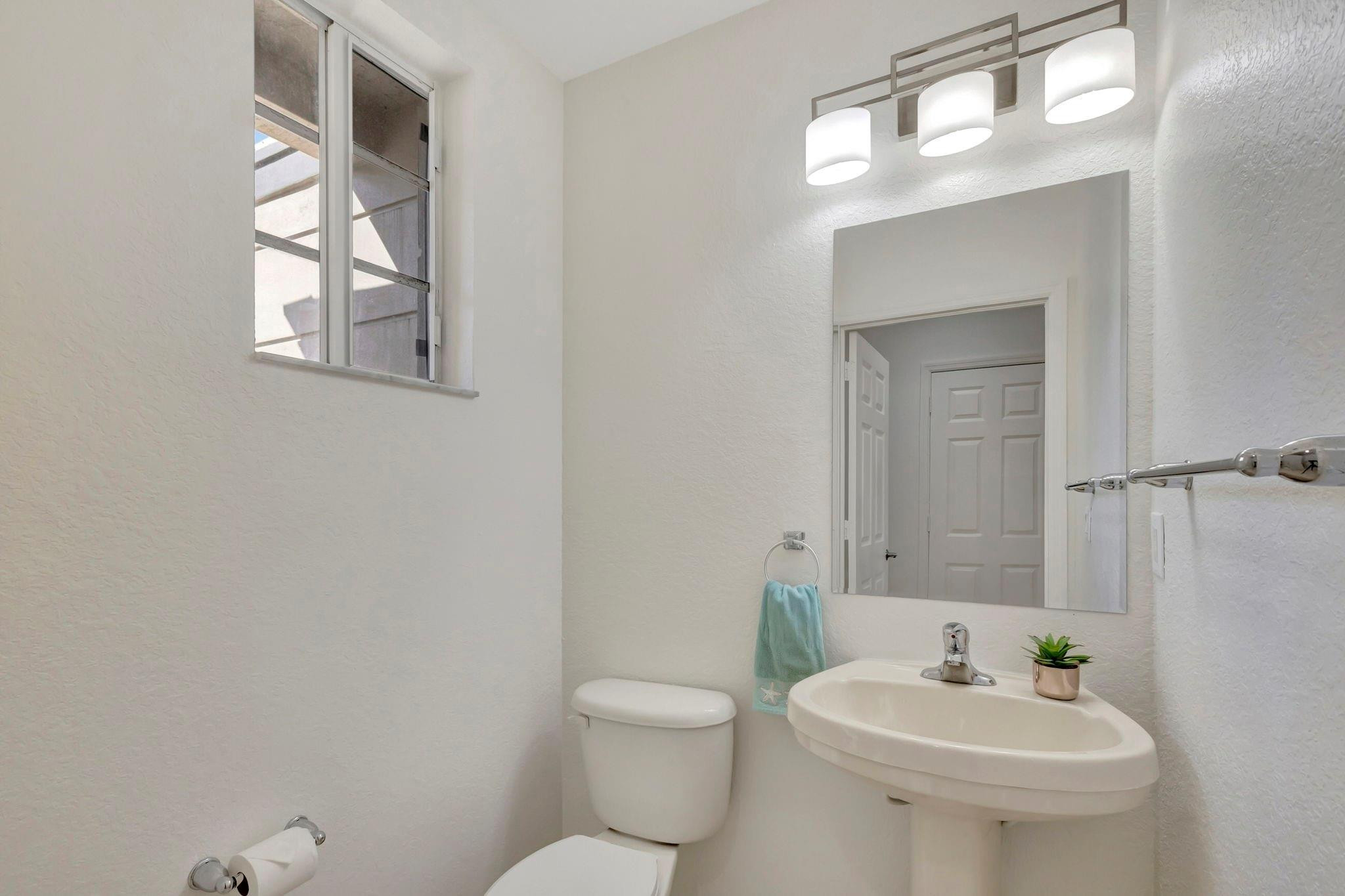 1000 Flamingo Place Riviera Beach, FL 33404 - Photo 18 of 83 a bathroom with a toilet a sink and mirror