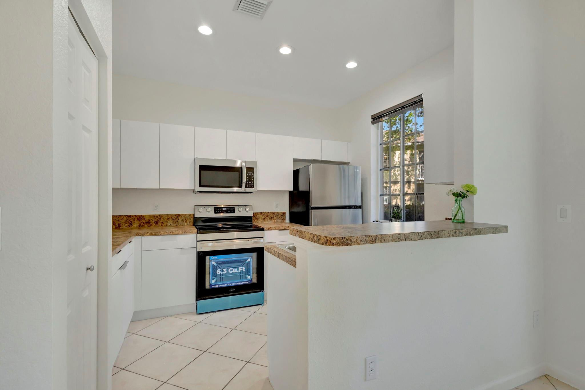 1000 Flamingo Place Riviera Beach, FL 33404 - Photo 25 of 83 a kitchen with stainless steel appliances granite countertop a stove and a refrigerator