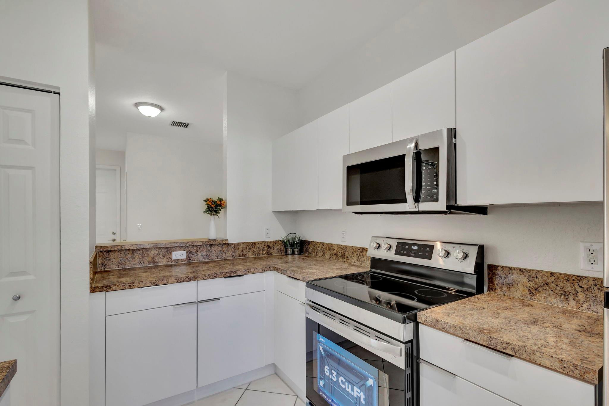 1000 Flamingo Place Riviera Beach, FL 33404 - Photo 26 of 83 a kitchen with stainless steel appliances granite countertop a stove microwave and sink
