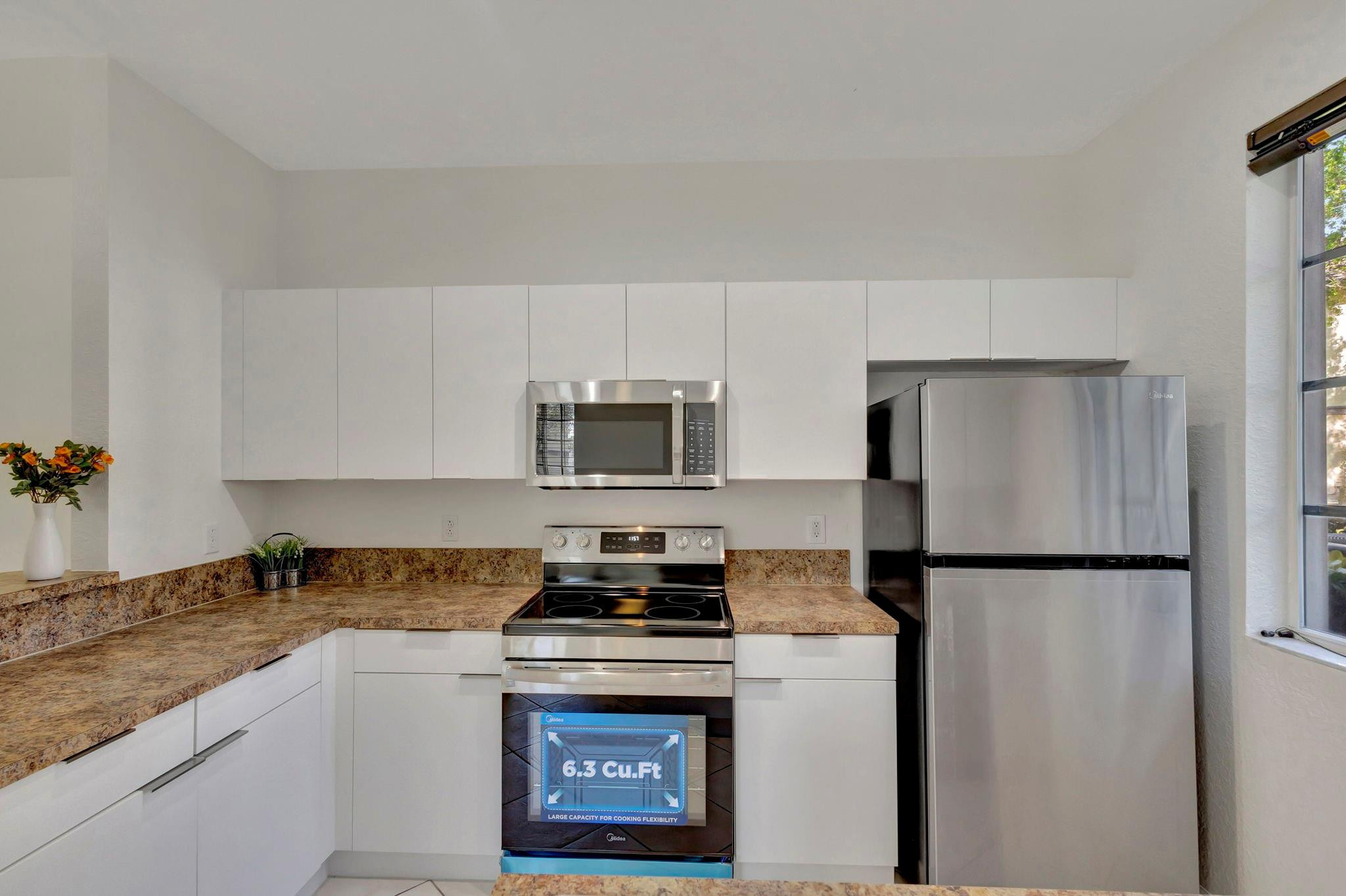 1000 Flamingo Place Riviera Beach, FL 33404 - Photo 27 of 83 a kitchen with a refrigerator stove and microwave