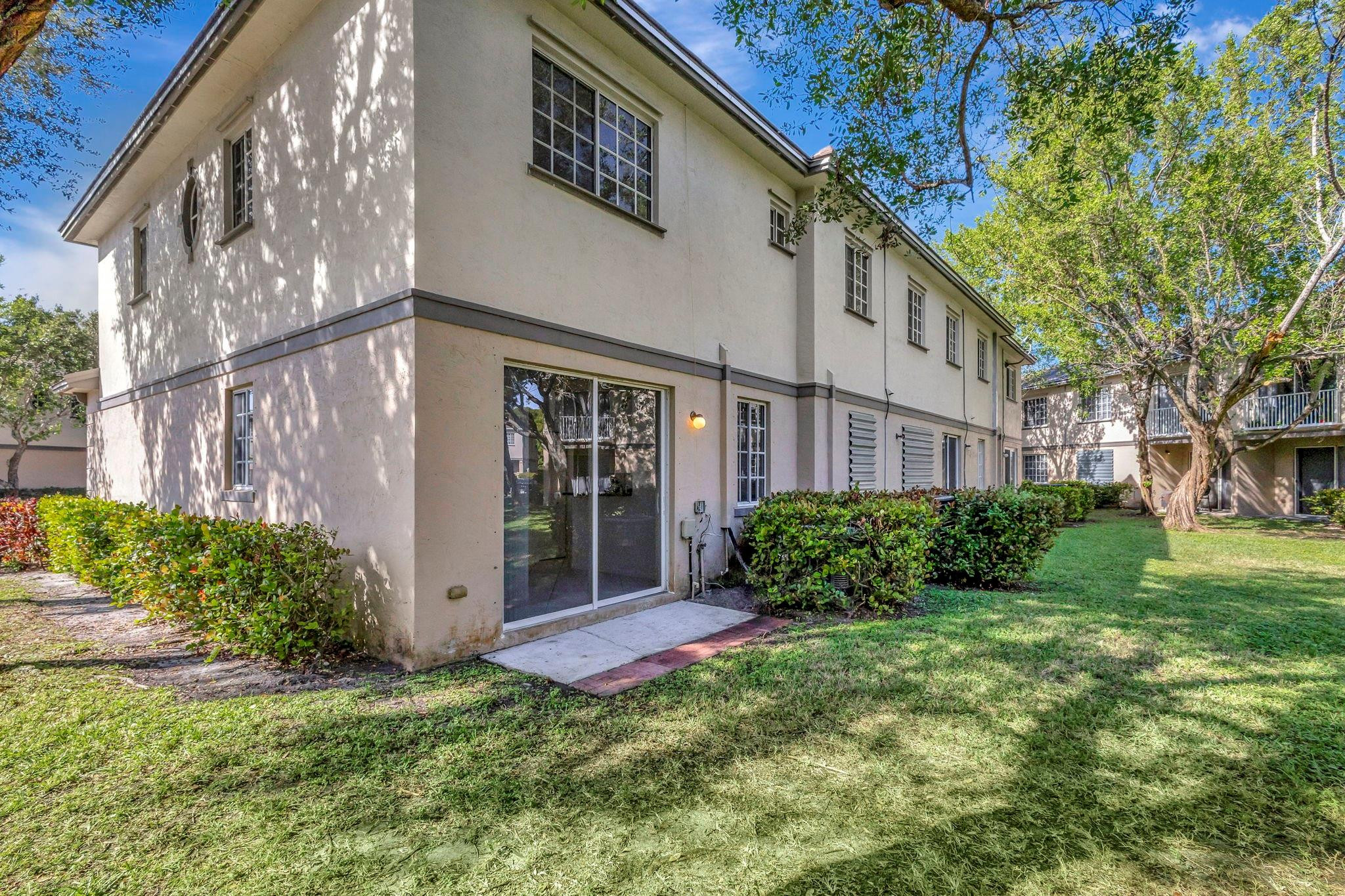 1000 Flamingo Place Riviera Beach, FL 33404 - Photo 32 of 83 a view of a brick house with a large windows plants and large trees