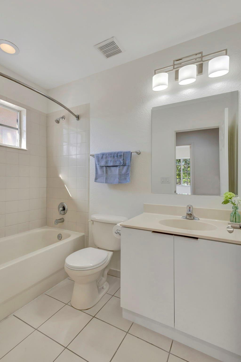 1000 Flamingo Place Riviera Beach, FL 33404 - Photo 49 of 83 a bathroom with a granite countertop sink a toilet mirror and bathtub