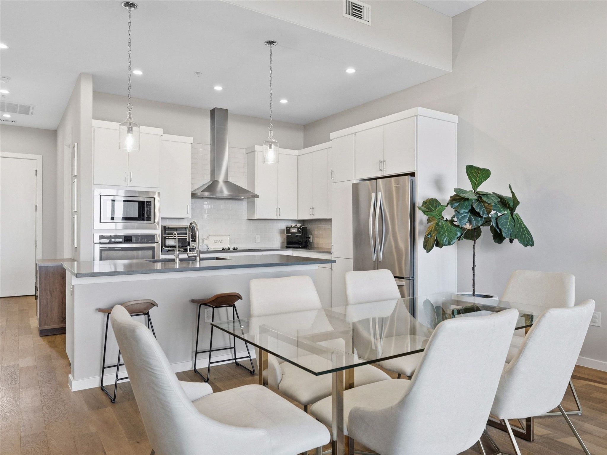 5921 Hiline Road, Unit 1303 Austin, TX 78734 - Photo 13 of 37 a kitchen with stainless steel appliances granite countertop a dining table chairs refrigerator and sink