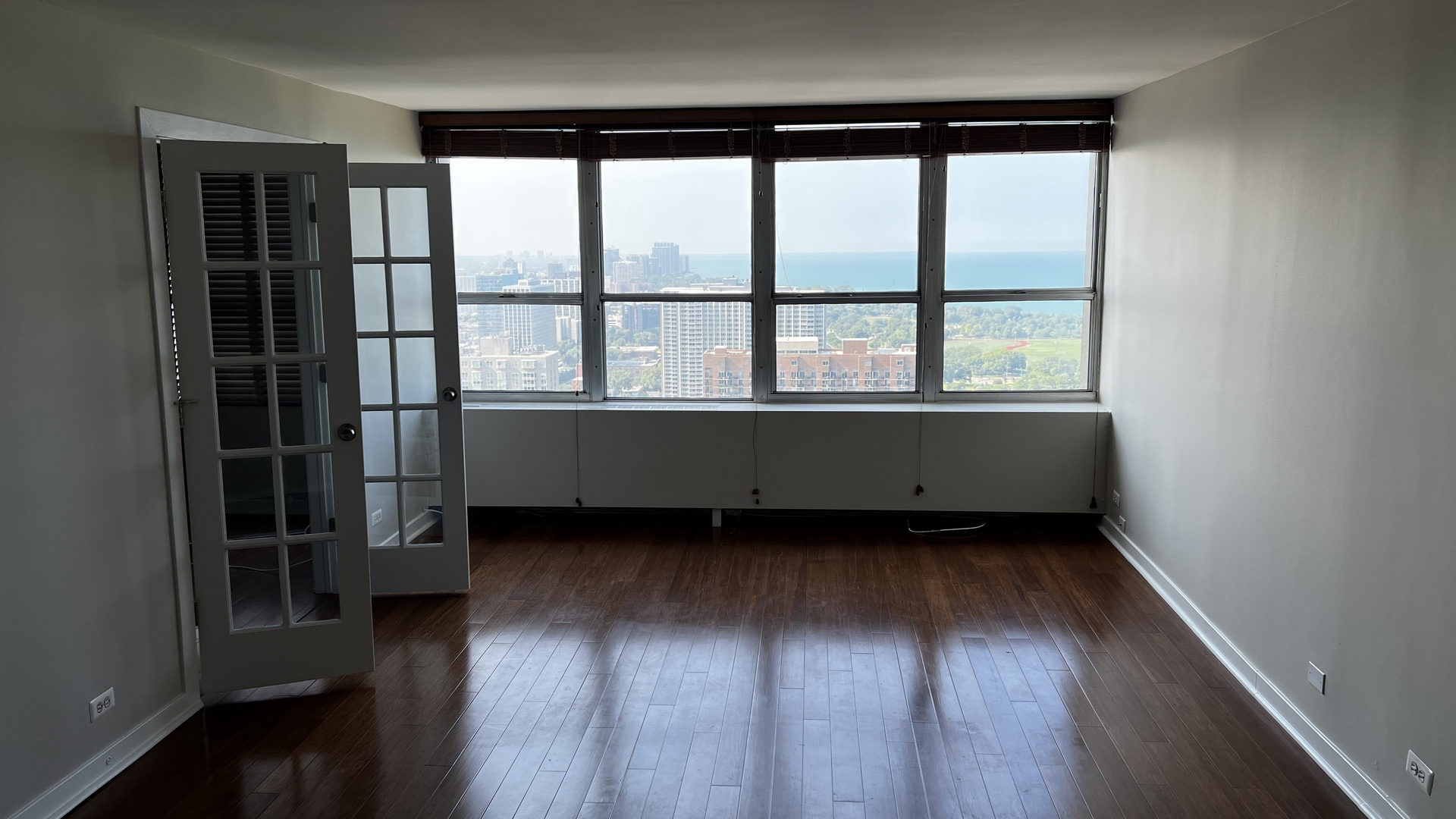 655 West Irving Park Road, Unit 3804 Chicago, IL 60613 - Photo 3 of 8 an empty room with wooden floor and windows