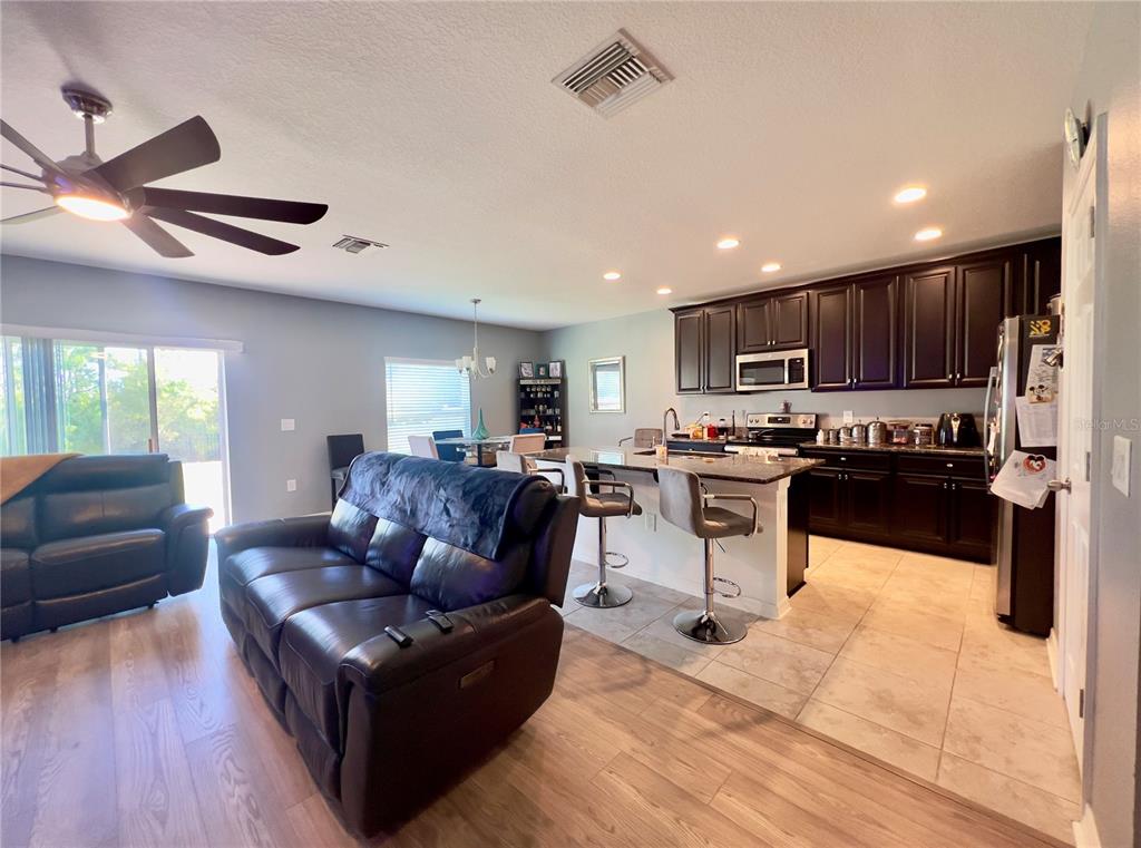 13149 Conquistador Loop Spring Hill, FL 34610 - Photo 12 of 30 a living room with stainless steel appliances kitchen island granite countertop a couch and a view of living room