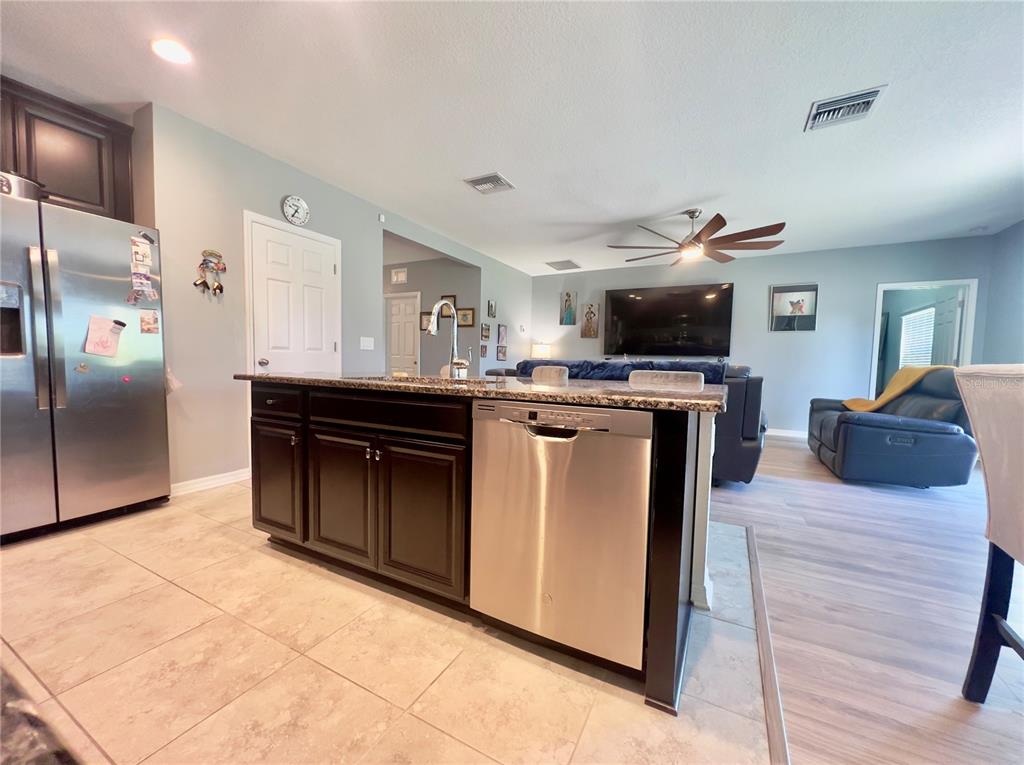 13149 Conquistador Loop Spring Hill, FL 34610 - Photo 16 of 30 a kitchen with stainless steel appliances granite countertop a stove top oven and cabinets