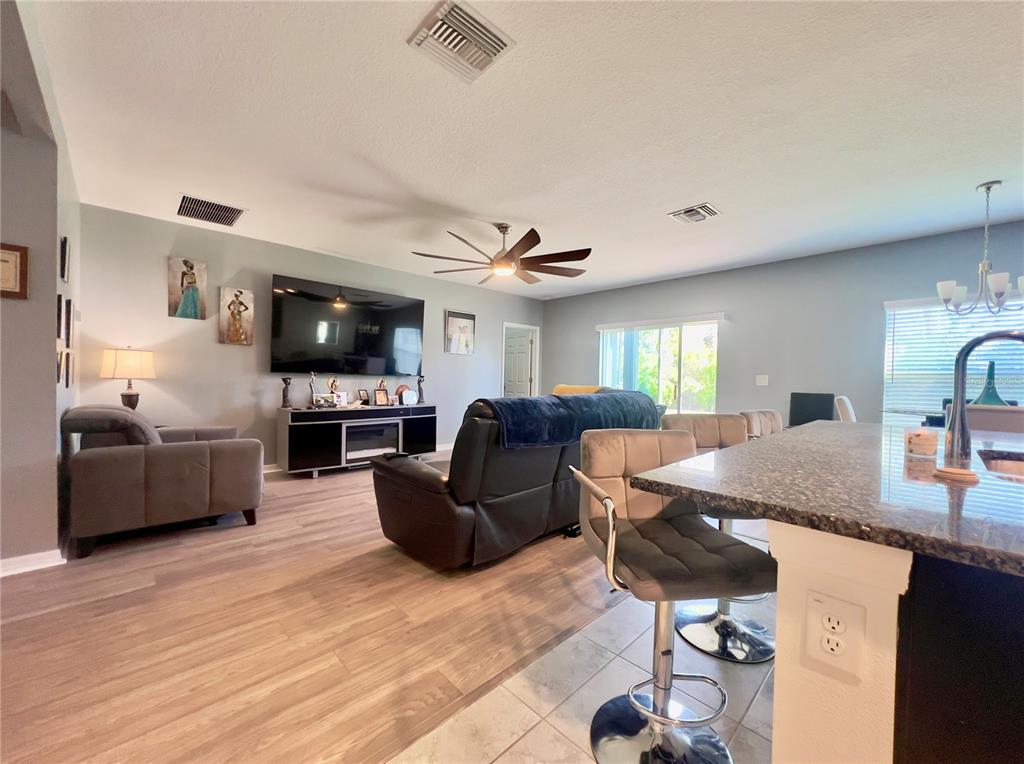 13149 Conquistador Loop Spring Hill, FL 34610 - Photo 17 of 30 a living room with furniture a flat screen tv and kitchen view
