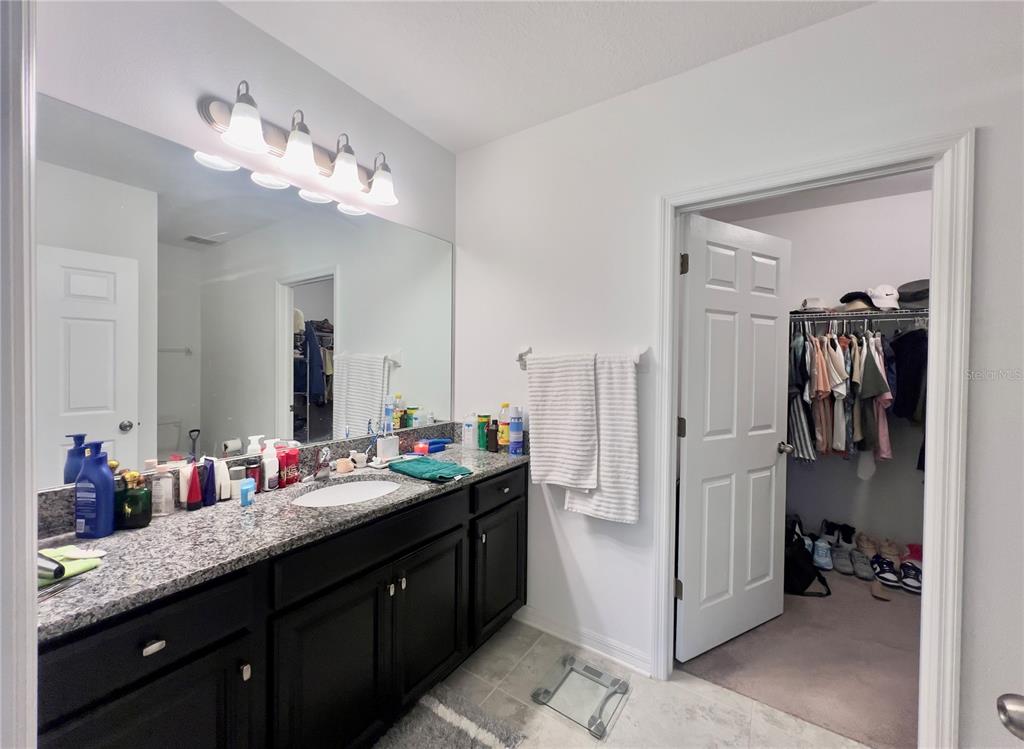 13149 Conquistador Loop Spring Hill, FL 34610 - Photo 20 of 30 a spacious bathroom with a granite countertop sink and a mirror