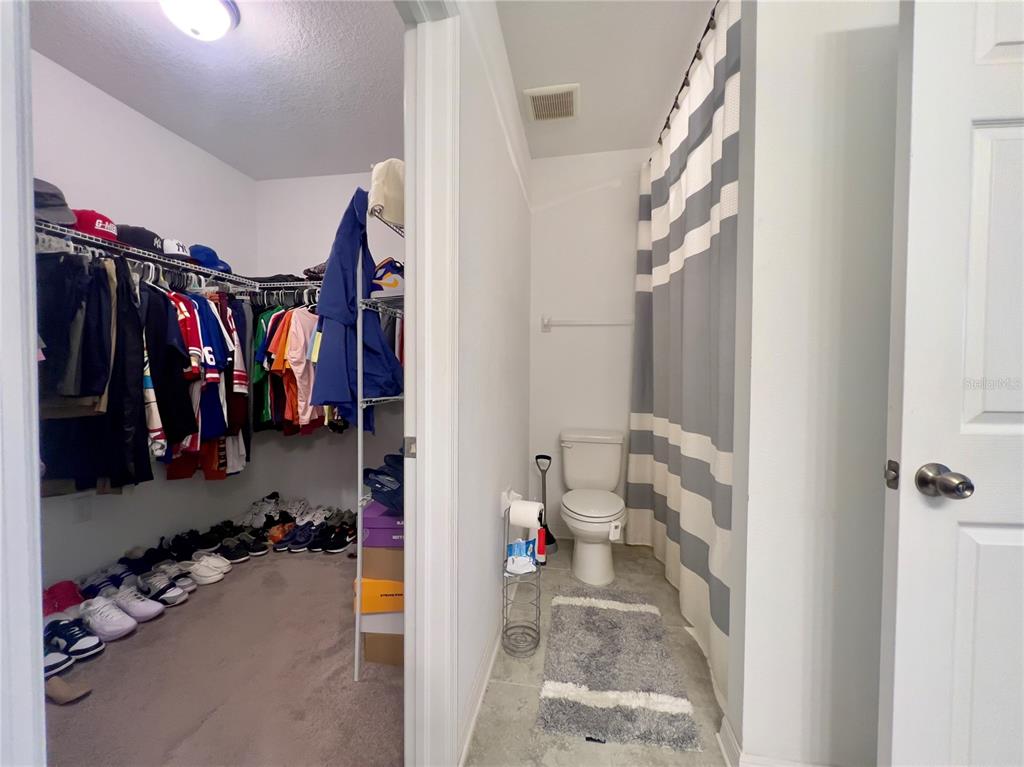 13149 Conquistador Loop Spring Hill, FL 34610 - Photo 21 of 30 a view of walk in closet with clothes and shoes
