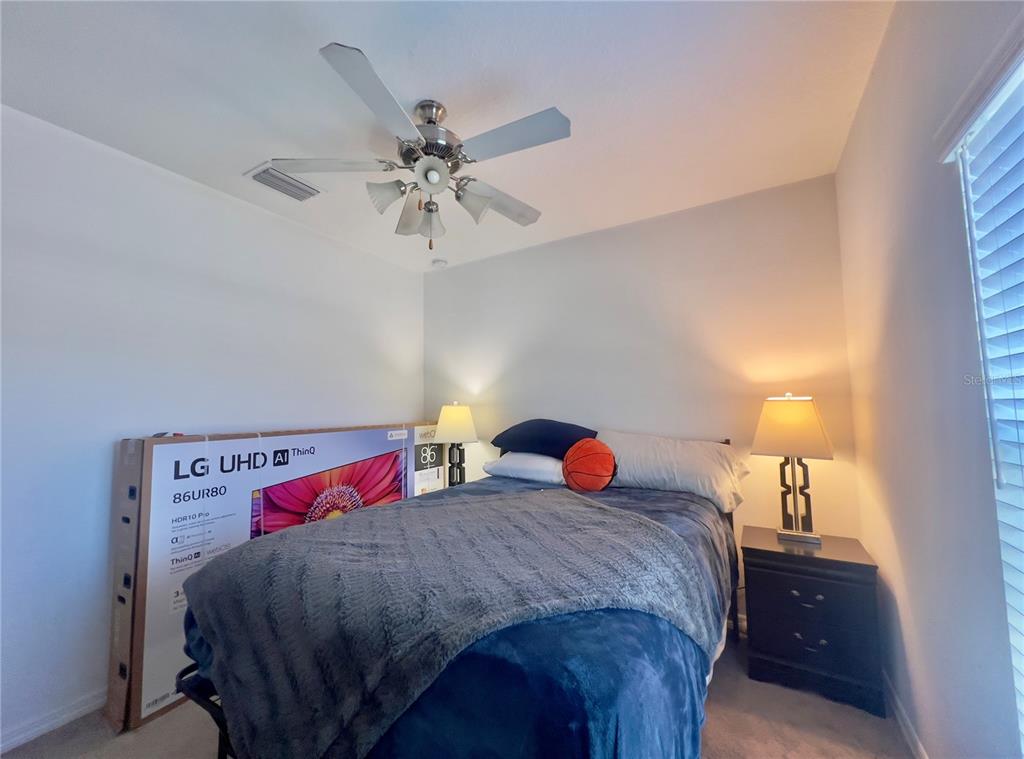 13149 Conquistador Loop Spring Hill, FL 34610 - Photo 22 of 30 a bedroom with 2 bed and a chandelier