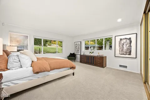 a bedroom with furniture and a large window