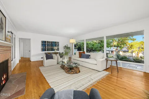 a table and chairs sitting in a room with a large window