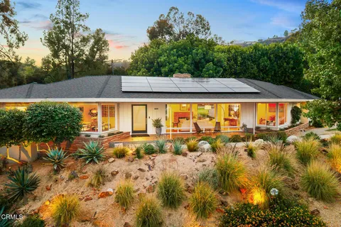 a view of a swimming pool with chairs in front of house
