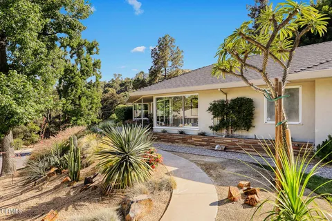 a couple of palm trees in front of a house