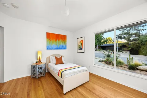 a bedroom with a bed and a painting on the wall