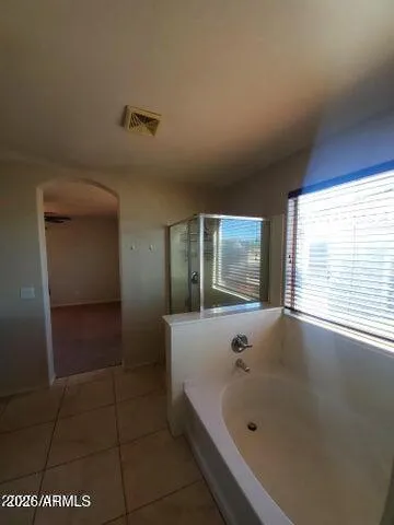 a bathroom with a tub a window and glass door