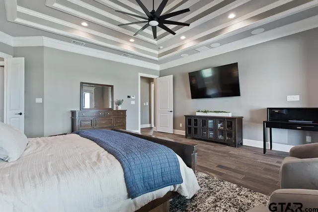 a spacious bedroom with a bed and a flat screen television