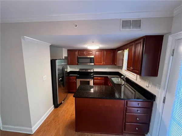 a kitchen with granite countertop a refrigerator stove and sink