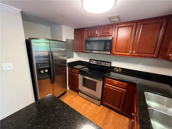 a kitchen with stainless steel appliances wooden cabinets and a stove top oven