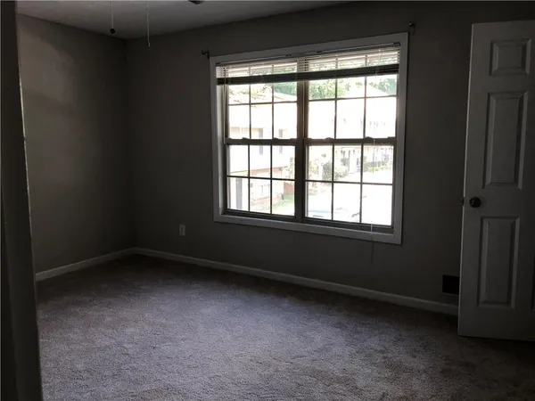an empty room with windows and closet