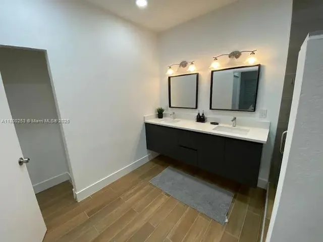 a bathroom with a double vanity sink and mirror