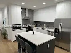 a kitchen with a sink a kitchen island and stainless steel appliances