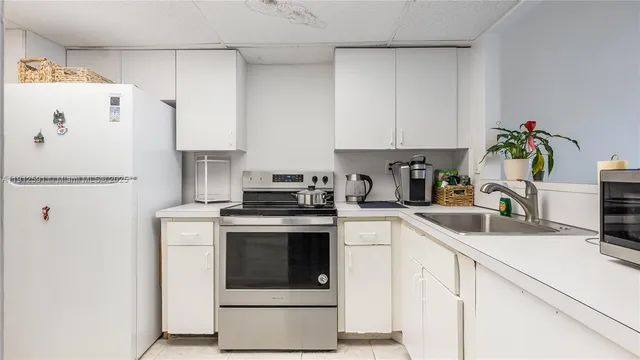 a kitchen with a white stove and white cabinets