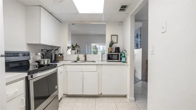 a kitchen with white cabinets and white appliances