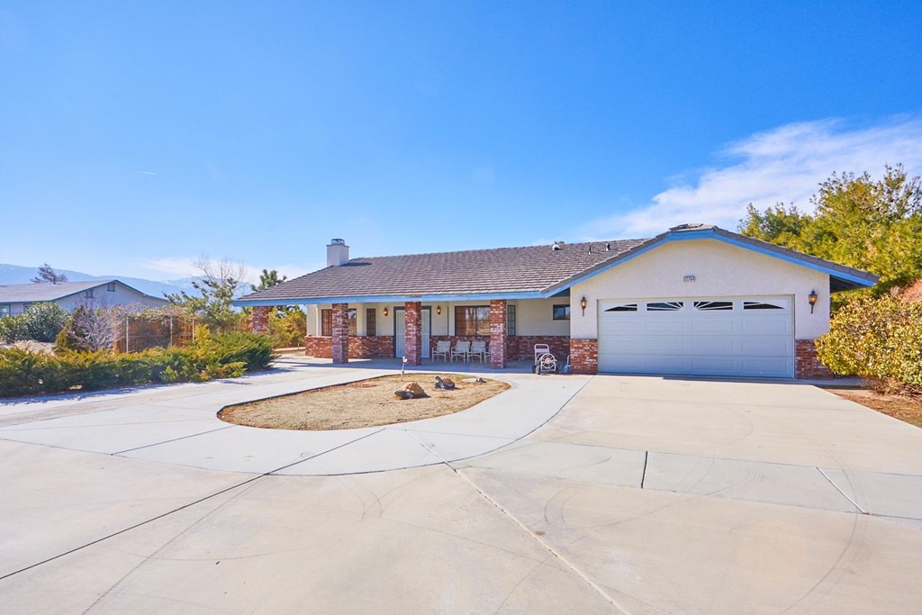 12764 Oasis Road Pinon Hills, CA 92372 - Photo 1 of 1 a front view of a house with a yard and garage