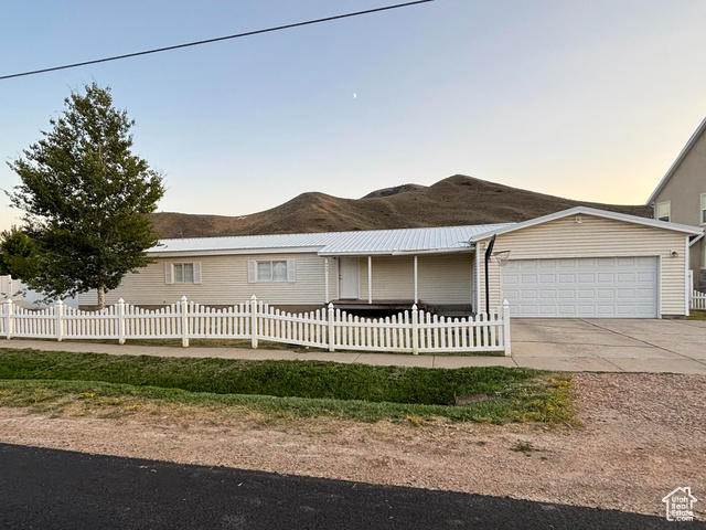 335 Memorial Park Road Henefer, UT 84033 - Photo 2 of 51 Ranch-style house with a fenced front yard, a garage, concrete driveway, and a mountain view
