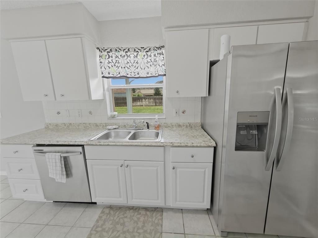 2202 Godfrey Avenue Spring Hill, FL 34609 - Photo 15 of 36 a kitchen with a sink a refrigerator and cabinets