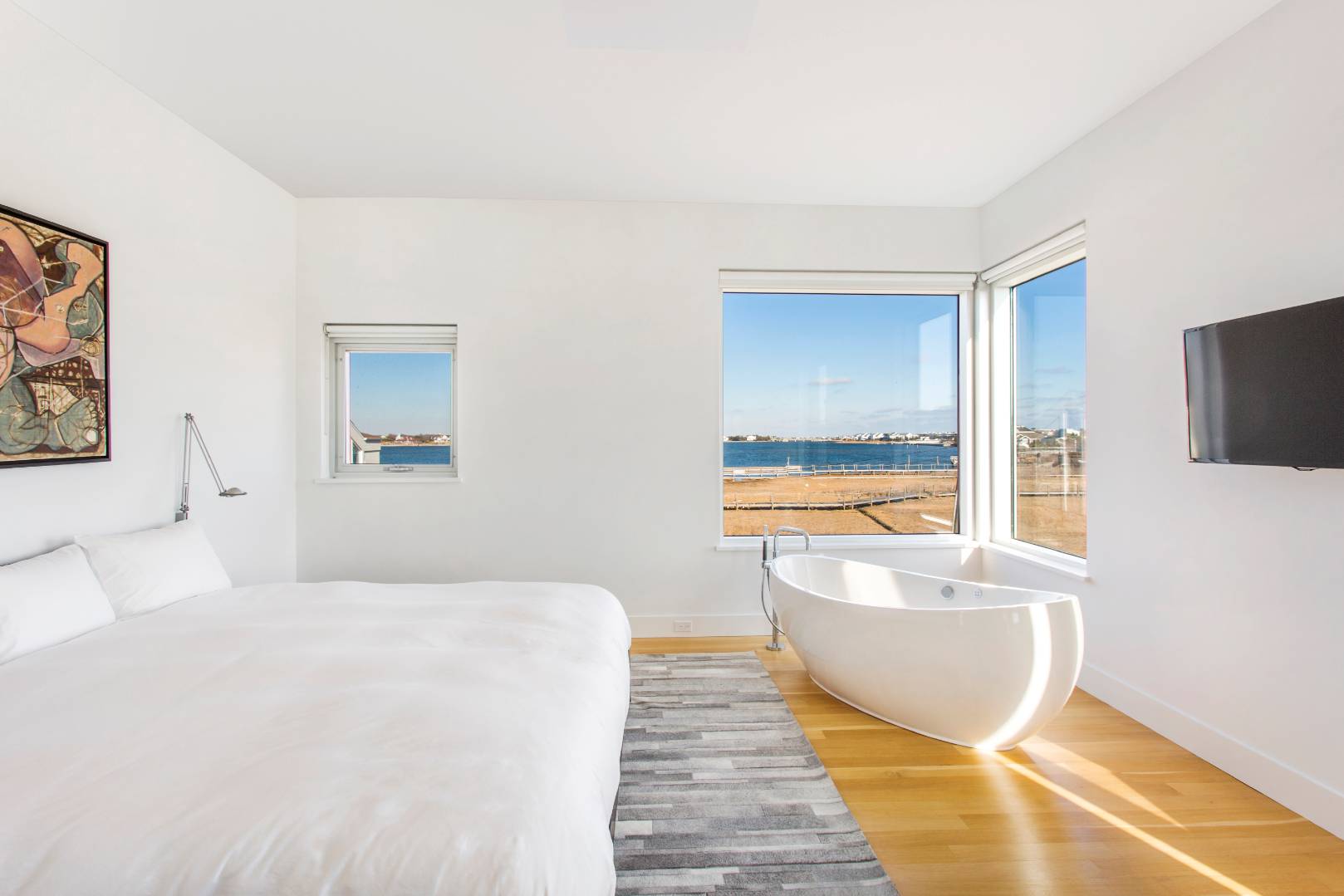 346 Dune Road Westhampton Beach, NY 11978 - Photo 6 of 13 a spacious bedroom with a bed and a flat tv screen