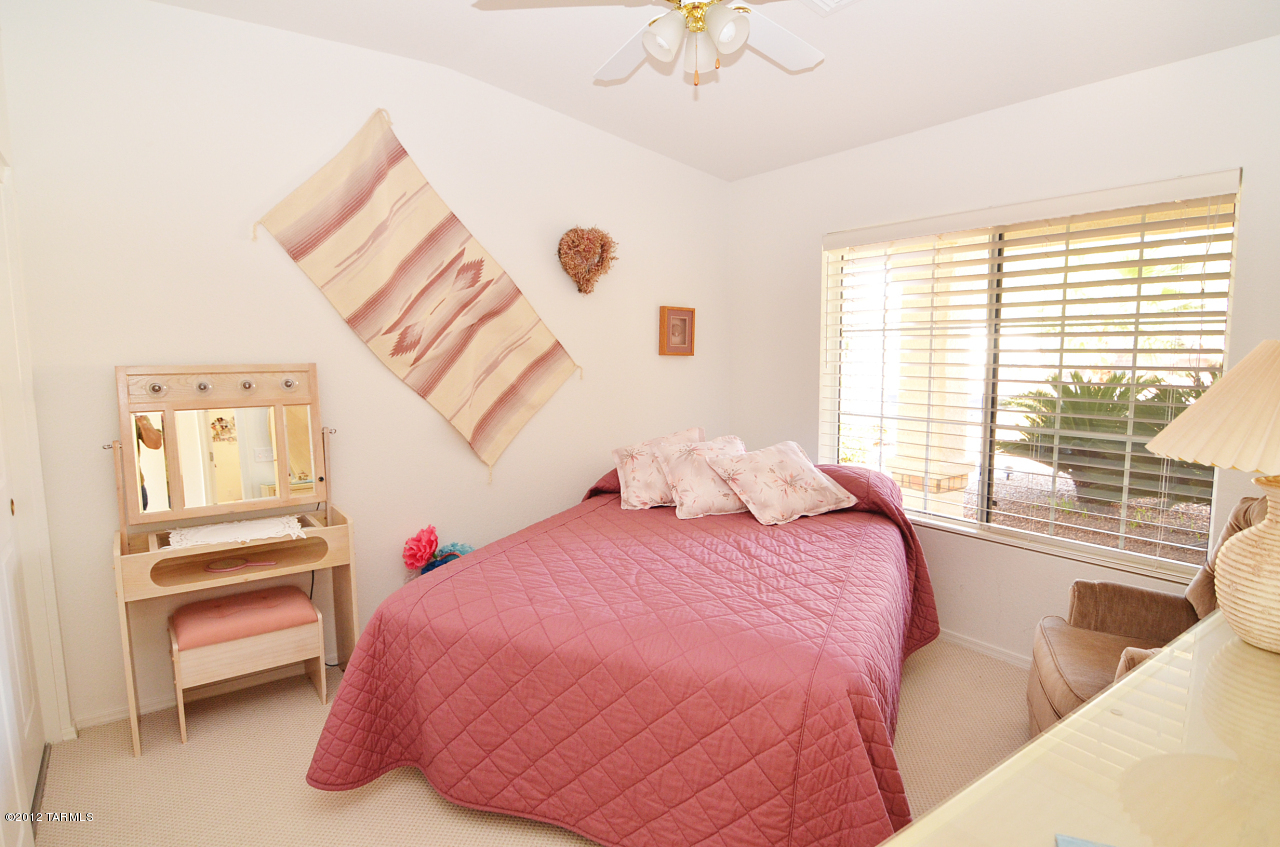 1330 East Crown Ridge Drive Tucson, AZ 85755 - Photo 13 of 22 a bedroom with a bed and a chandelier