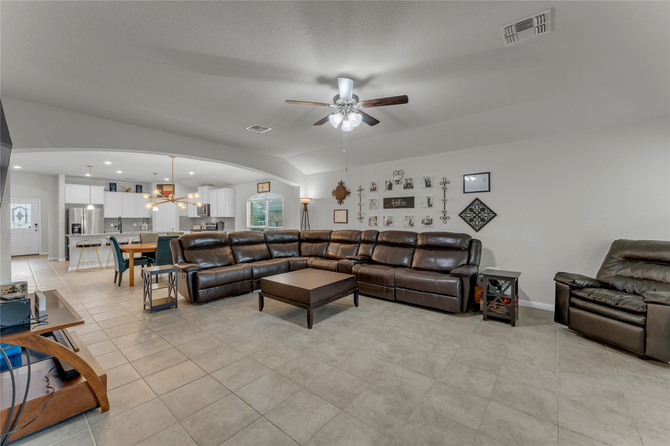 132 Cinnamon Loop Burnet, TX 78611 - Photo 8 of 27 Spacious living area featuring neutral tile flooring, vaulted ceilings, and a ceiling fan