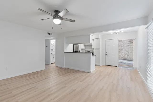 wooden floor in an empty room with a kitchen