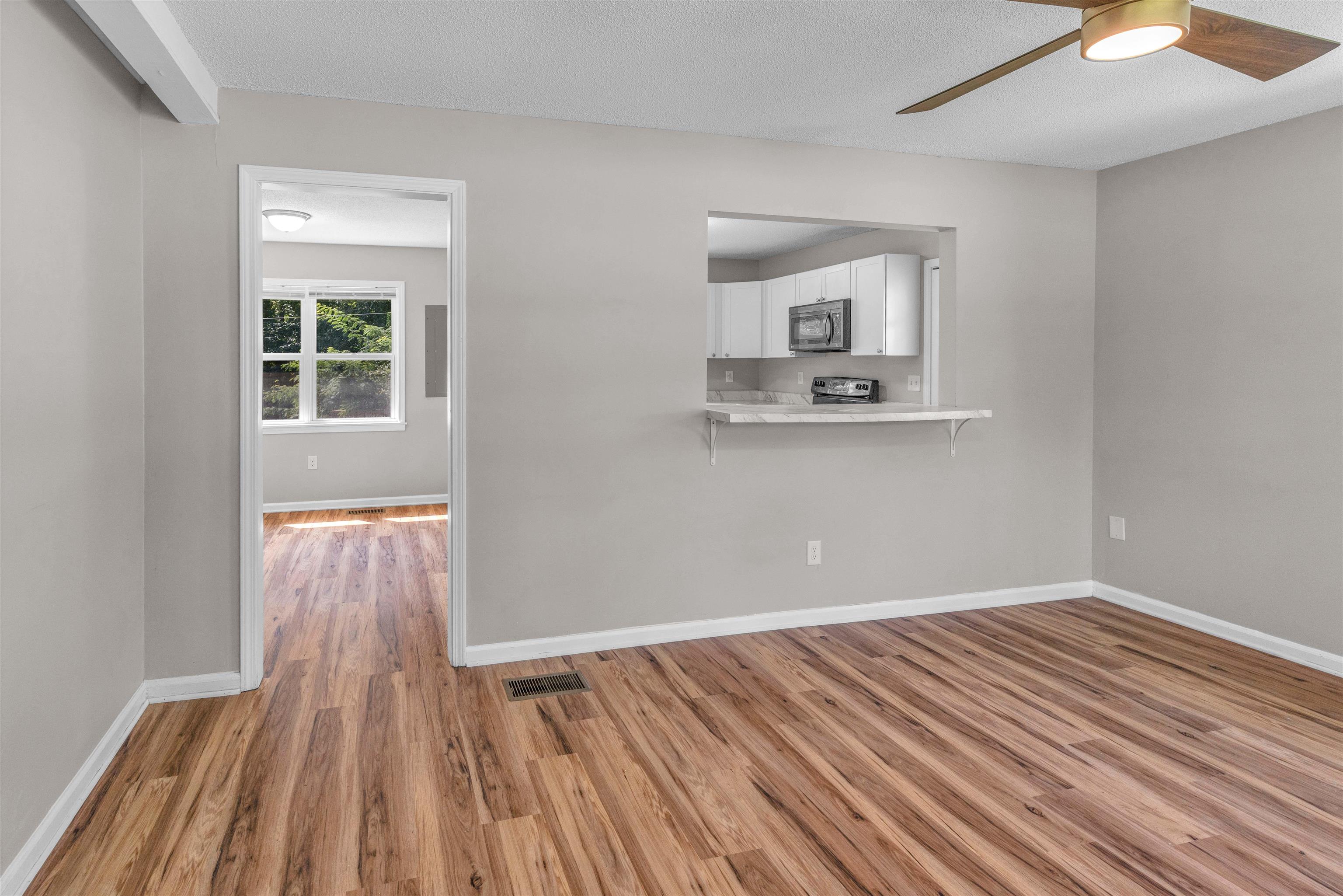 185 Henry Road Somerville, TN 38068 - Photo 6 of 21 Wood-finish flooring throughout, pass-through window with counter, ceiling fan, recessed lighting, and white trim