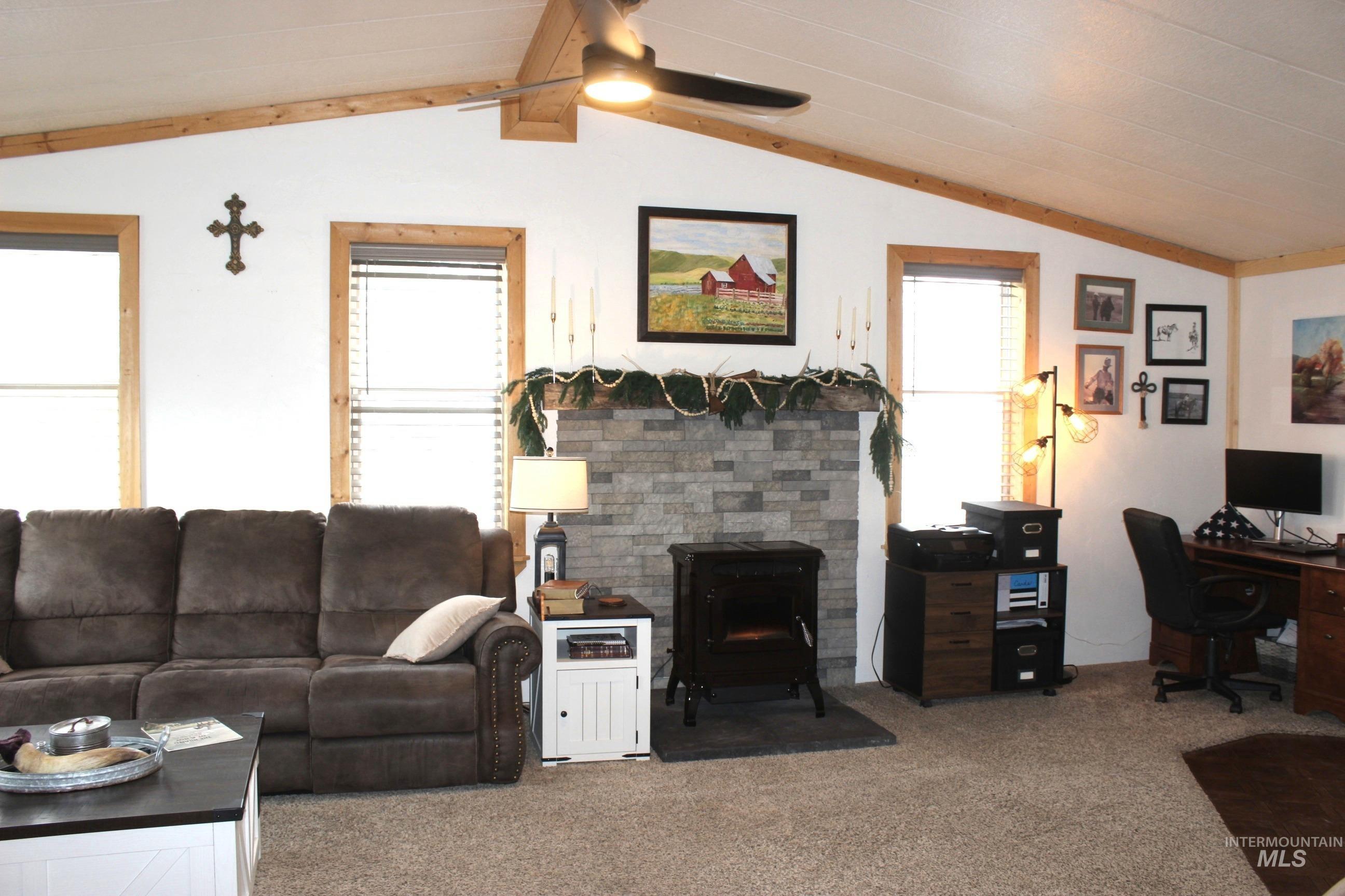 1824 Dutch Flat Road Midvale, ID 83645 - Photo 6 of 41 Carpeted living area featuring a wood stove, an office area, ceiling fan, healthy amount of natural light, and lofted ceiling