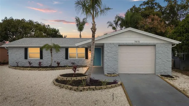 a front view of house with yard and trees in the background
