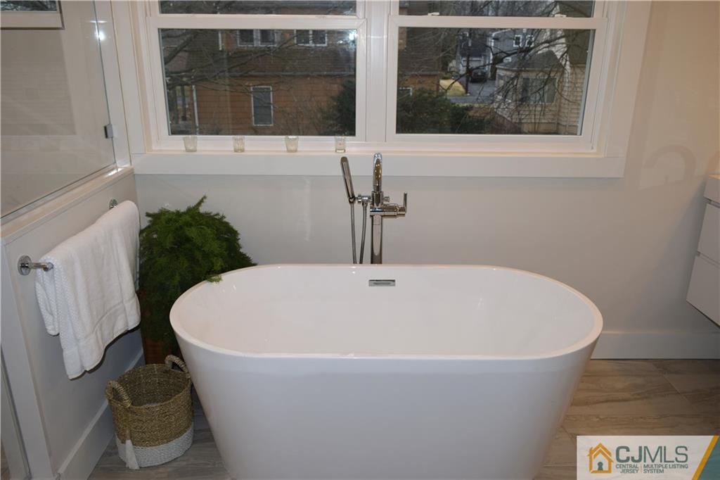 13 Cherokee Road Cranford, NJ 07016 - Photo 19 of 25 a white bath tub sitting in a bathroom