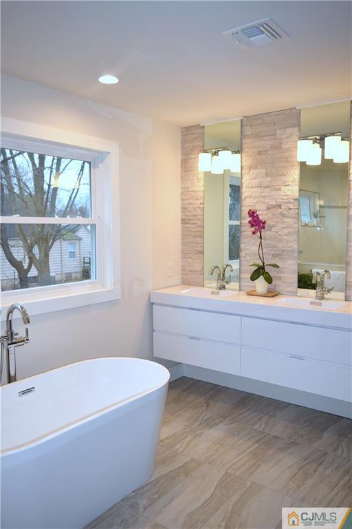 13 Cherokee Road Cranford, NJ 07016 - Photo 23 of 25 a bathroom with a bathtub sink and mirror