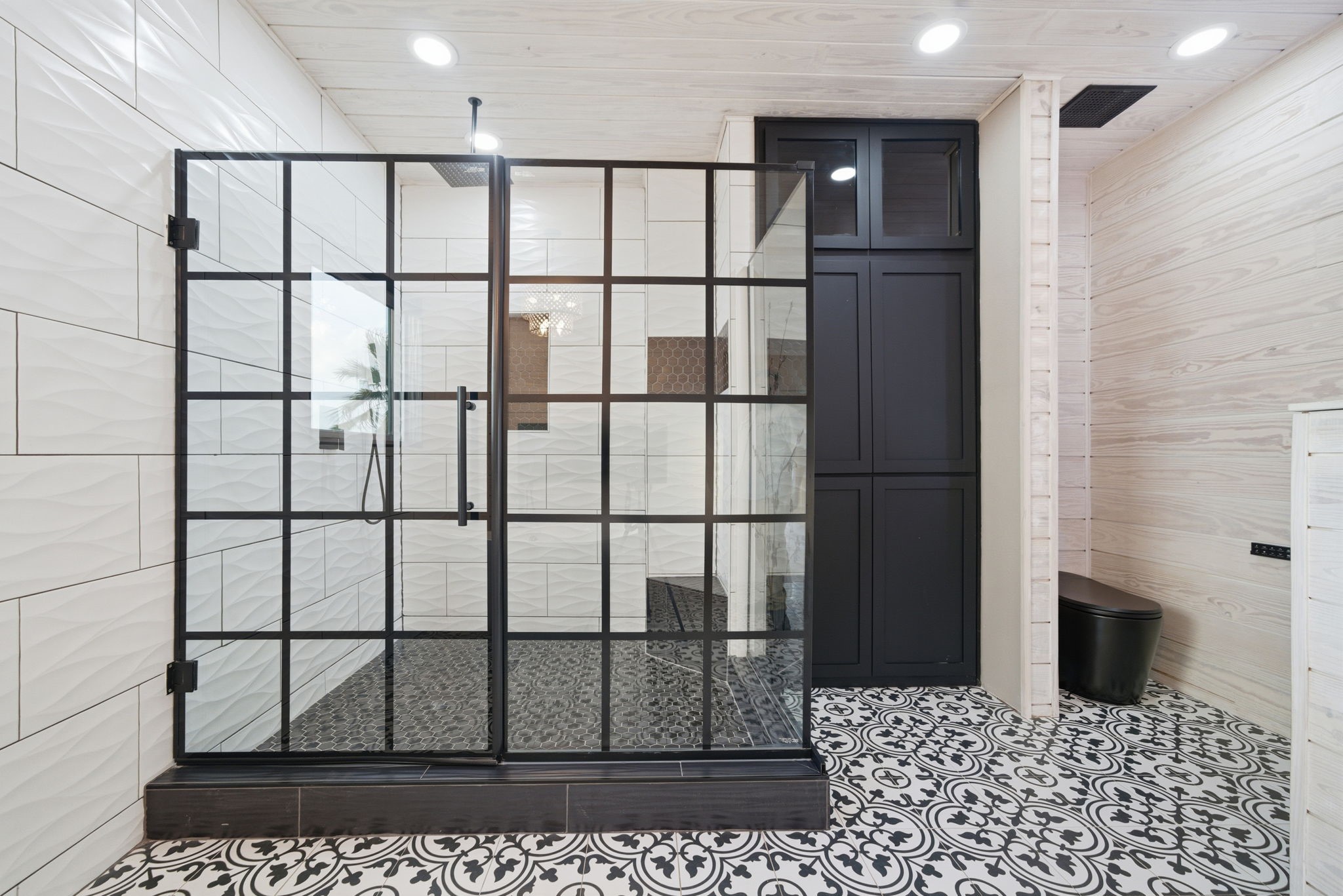 1918 Todville Road Seabrook, TX 77586 - Photo 32 of 41 Luxurious primary bath walk-in shower enclosed in striking black steel–frame glass, paired with a sleek built-in black storage cabinet that keeps linens and toiletries neatly tucked away.