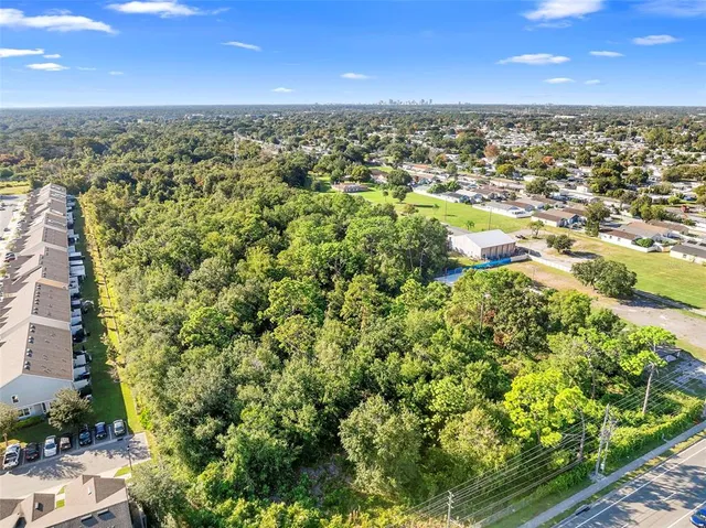an aerial view of residential houses with outdoor space and trees